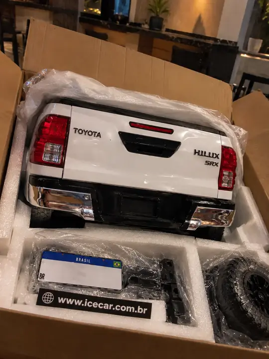 Cliente abrindo a caixa do ClubCasa com a réplica da Toyota Hilux SRX